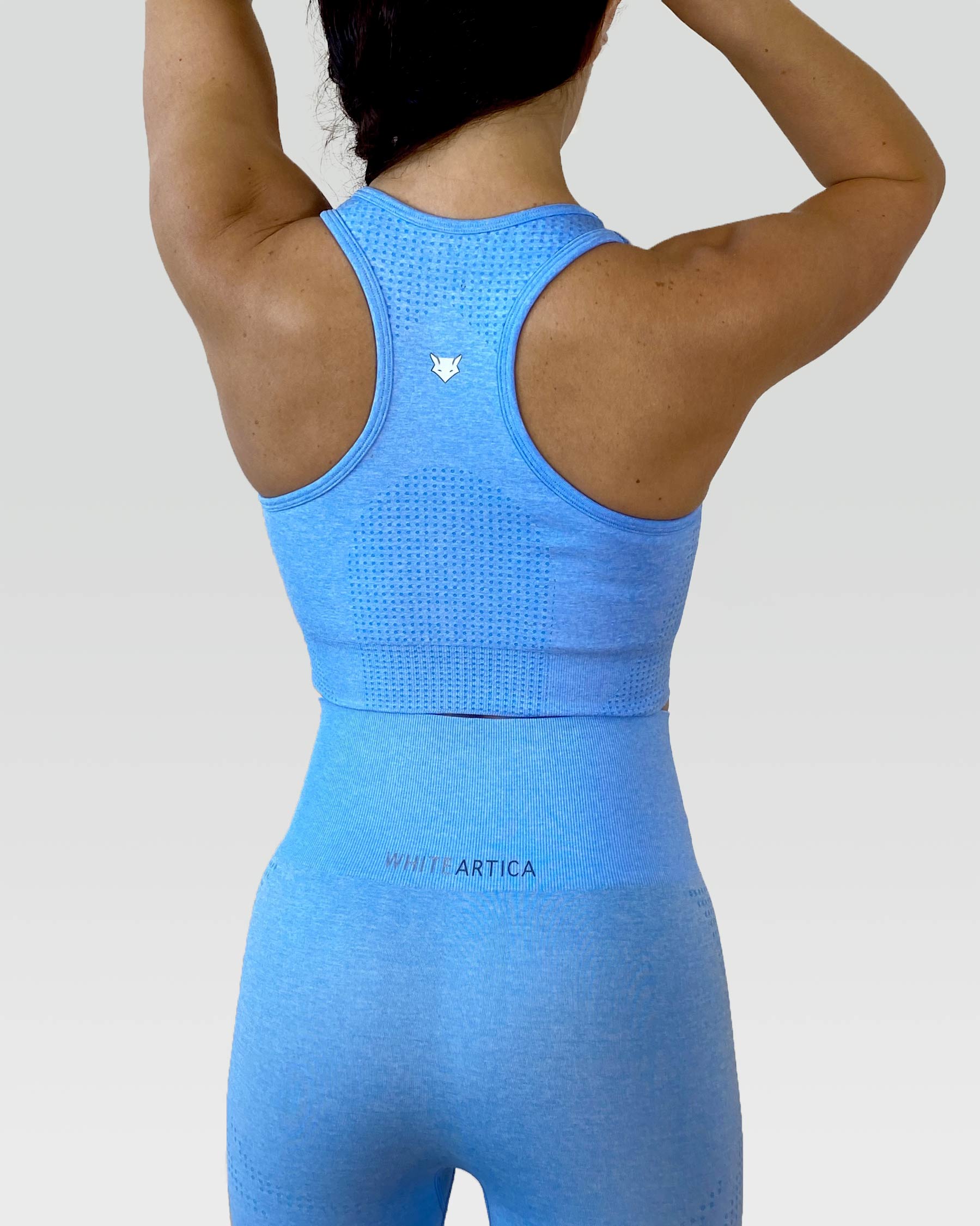 Australian woman wearing white artica high-waisted exercise pants and leggings activewear for her light blue activewear workout fitness cloths